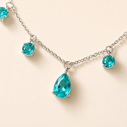 Close detail of teal pear-shaped and round dangle settings